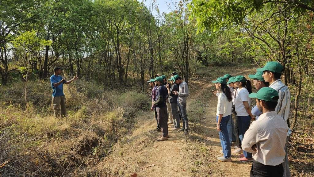 Field expert explaining students during trekking in forest of Melghat