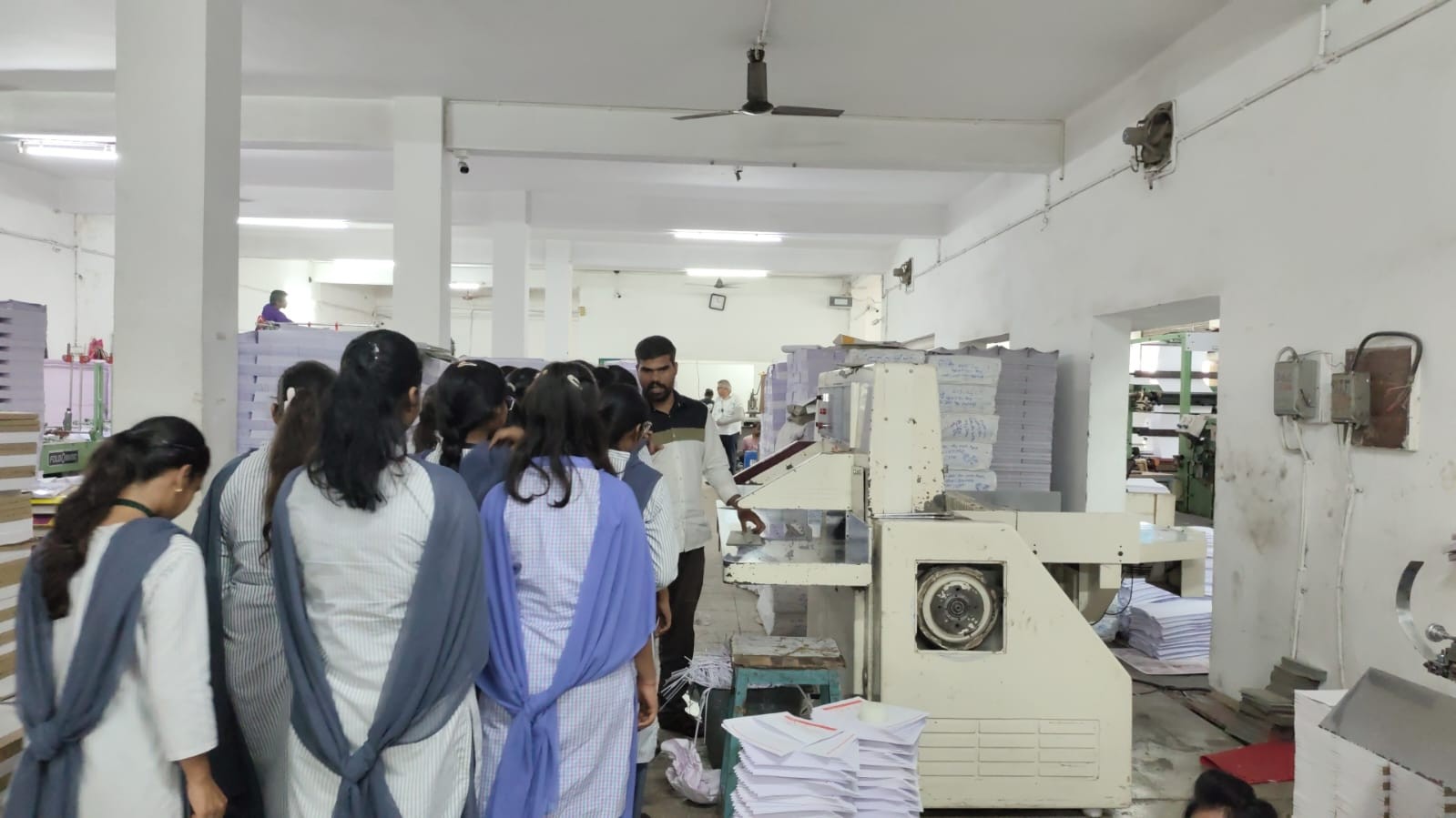 Technician Explaining the process of formation of different  products from plain paper 