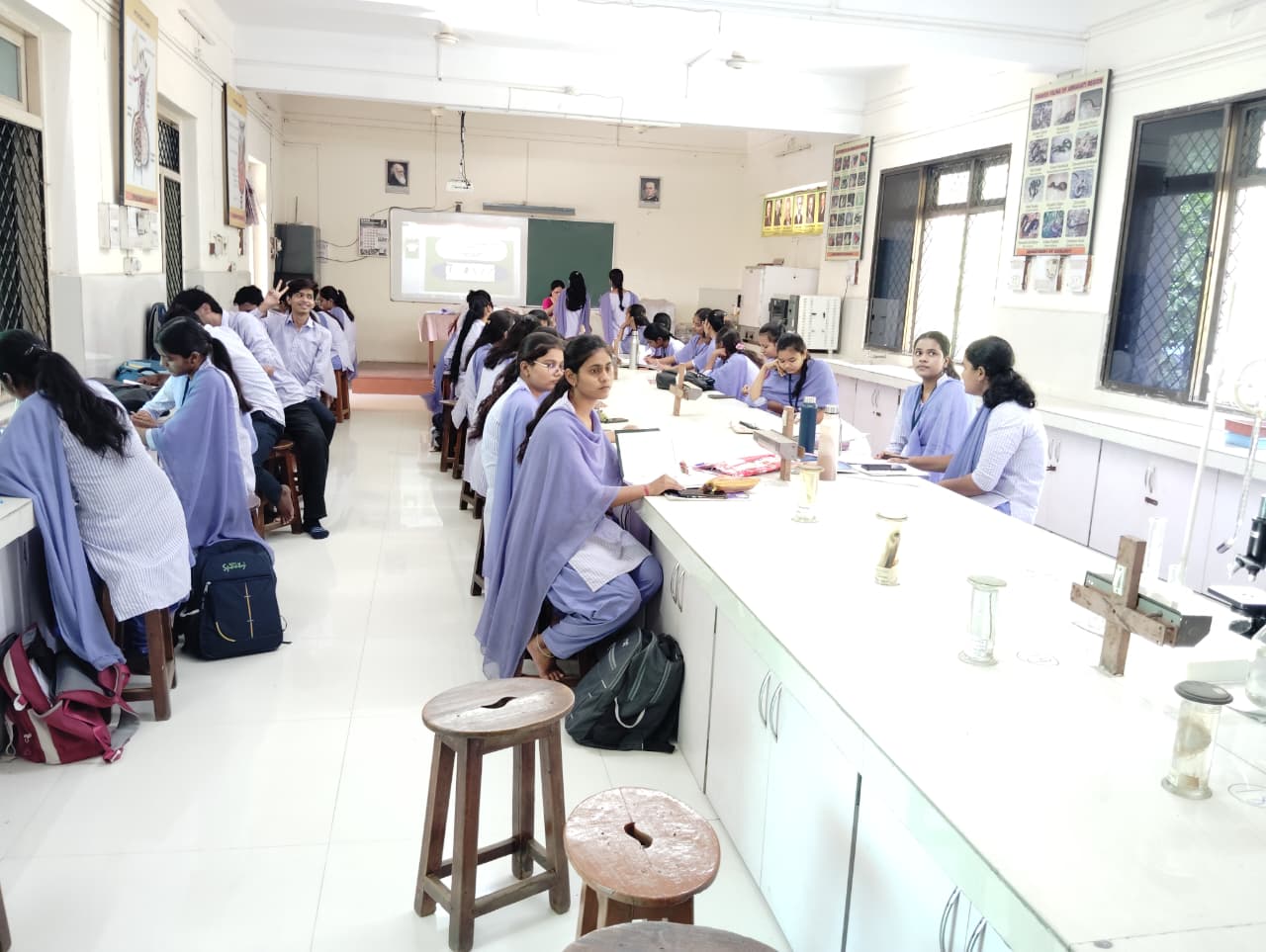 "Collaboration at the lens. Students work together to identify unique microscopic markers, a critical step in wildlife forensics and ecological research."